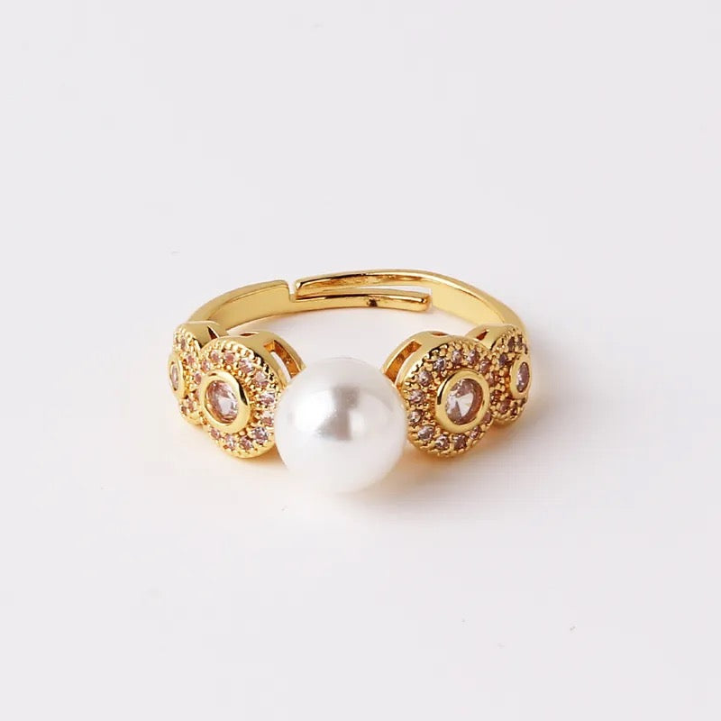 Elegant gold plated pave diamond encrusted adjustable ring with a statement pearl center, radiating sophistication and timeless beauty. Made with durable, long lasting, tarnish resistant material, this classically designed ring is perfect for making a statement, whether worn solo or stacked with other favorites.