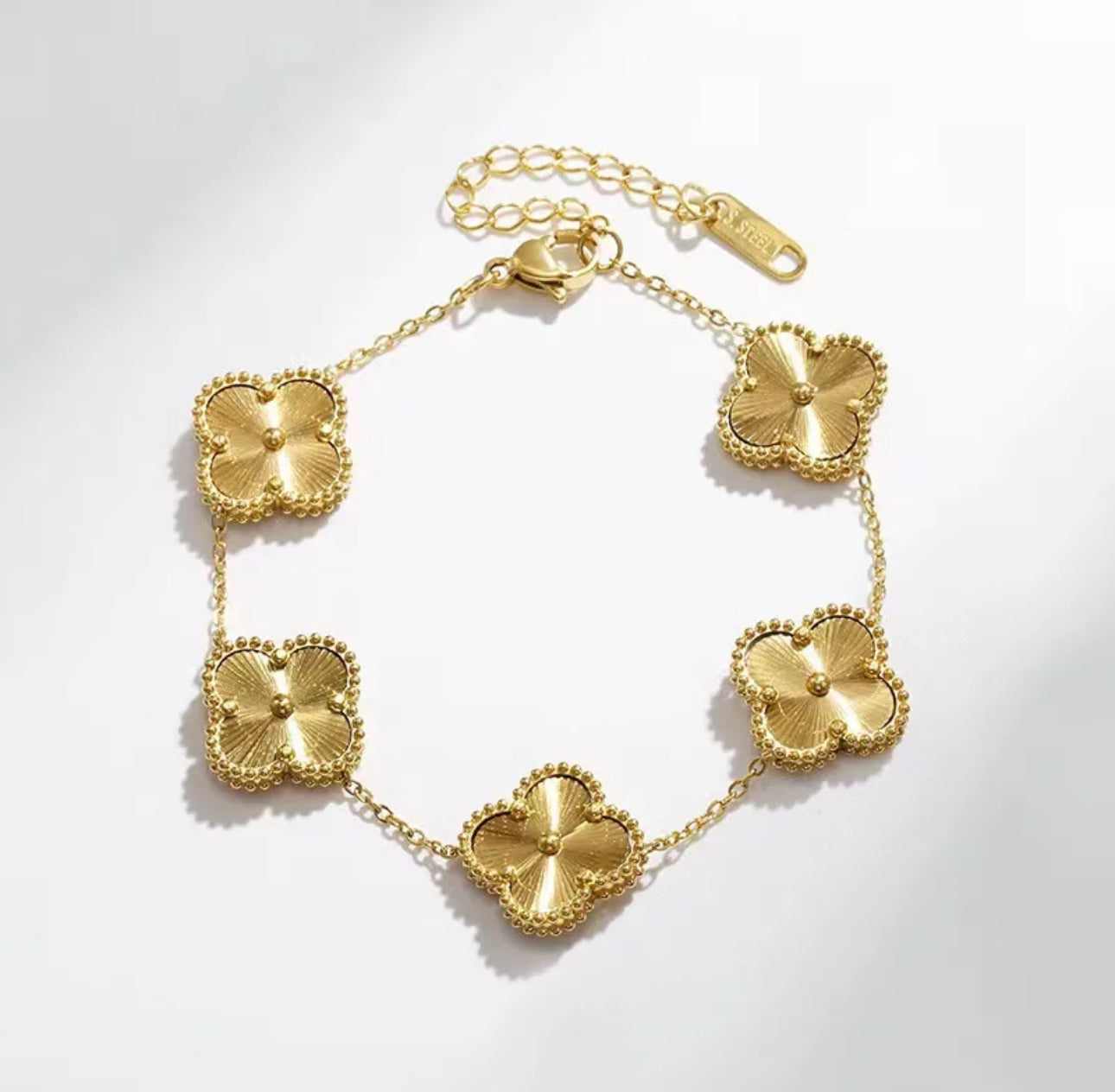 Close up front view of elegant 18K gold plated designer-inspired Van Cleef clover link chain bracelet. Lightweight and versatile design, with long lasting, waterproof plating perfect for any occasion, from casual outings to formal events. 