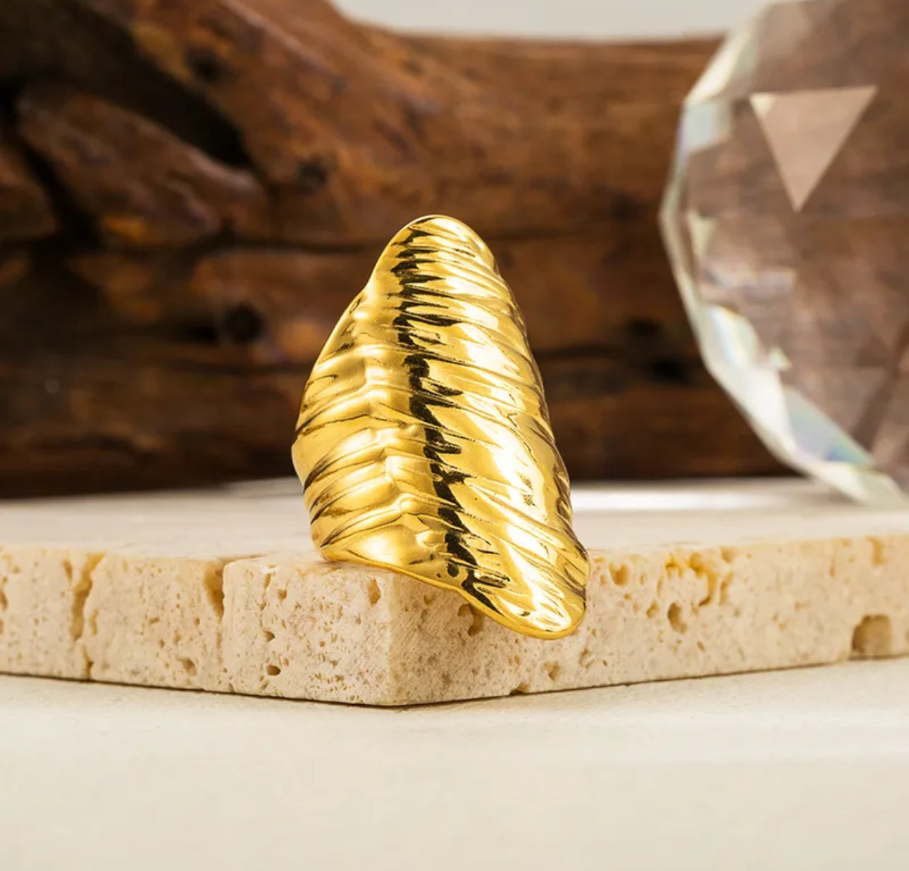 Close up view of elegant and durable 18k gold-plated 304 stainless steel, adjustable statement ring with a smooth polished finish, designed with a lightweight and tarnish resistant material for long wearing timeless sophistication.