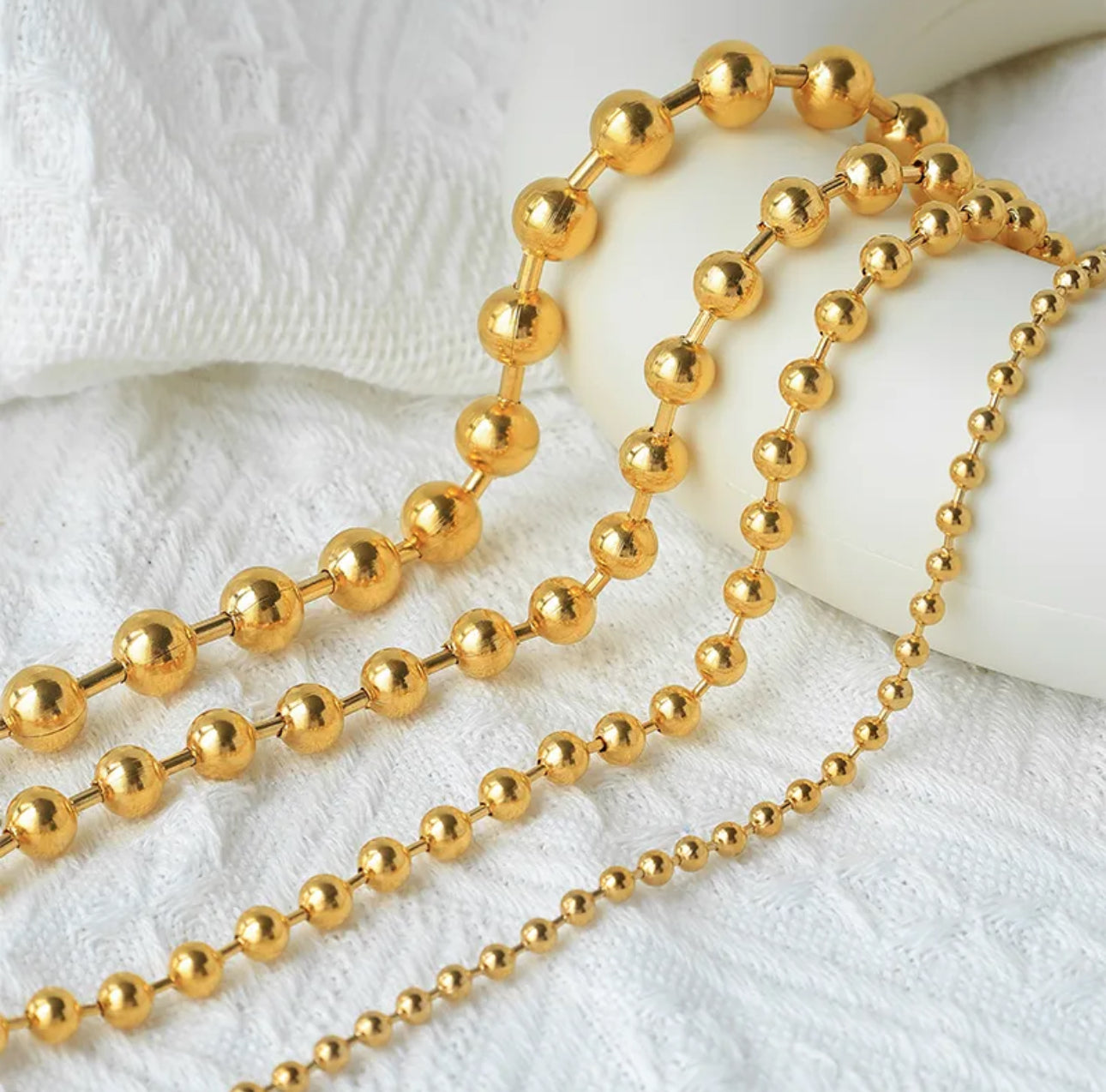 Close up view of 4 elegant 18k gold  plated stainless steel, designer inspired,  Tiffany ball chain necklace dupea with a smooth, polished finish, designed with a lightweight and tarnish resistant material for timeless sophistication.