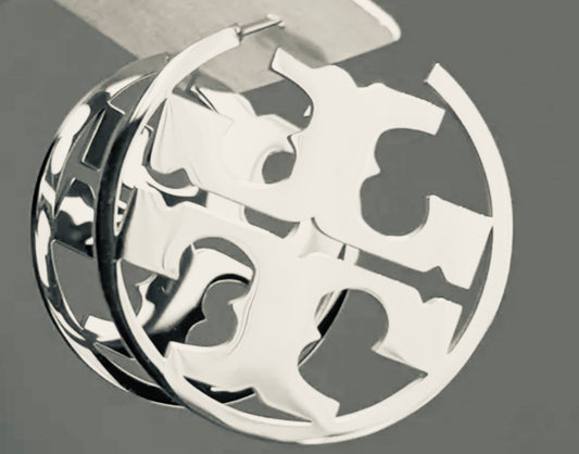 Close up side view of elegant 18k Silver plated stainless steel, Tory Burch designer inspired hoop earrings with a smooth, polished finish, designed with a lightweight and tarnish resistant material for timeless sophistication.