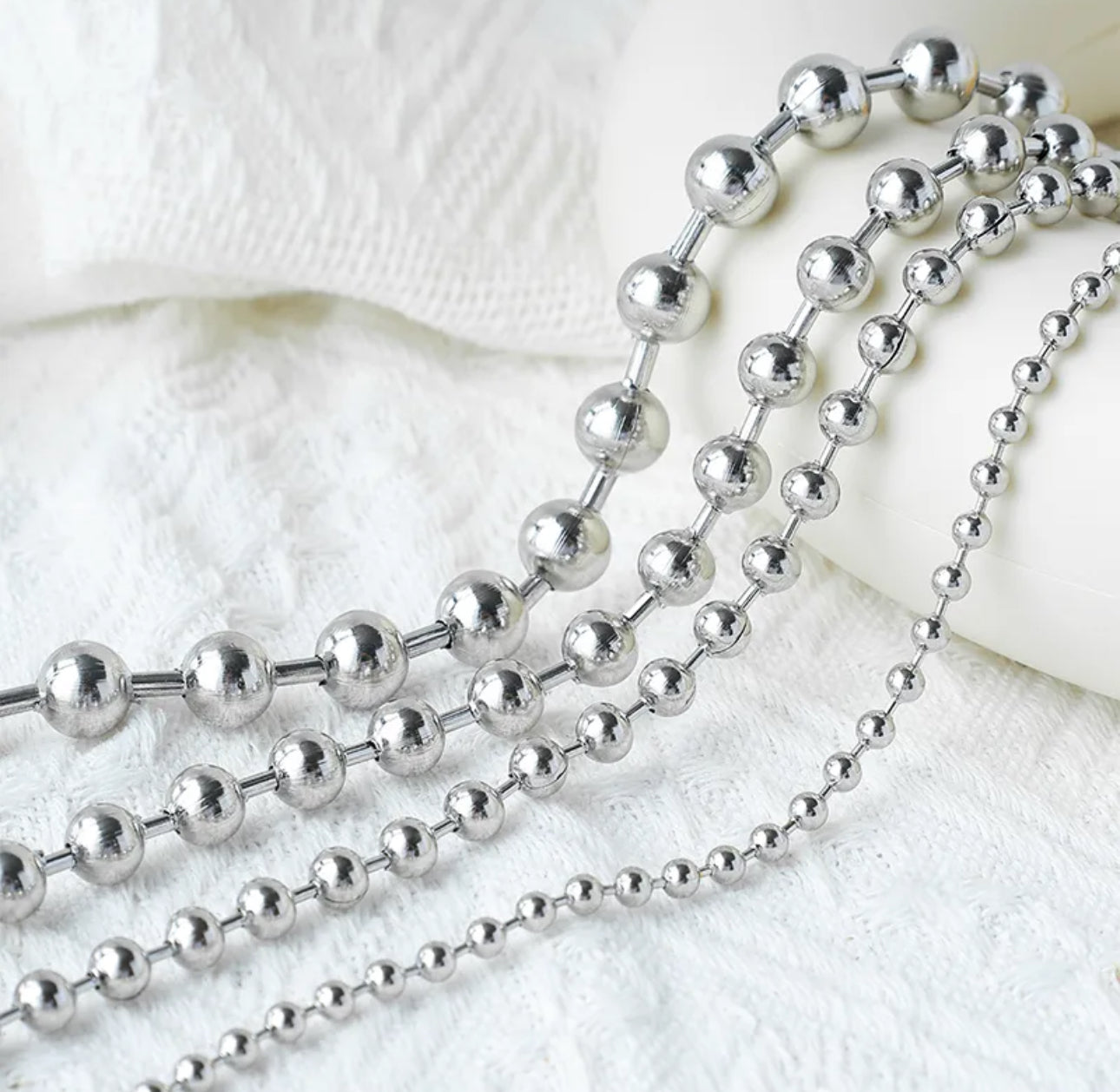 Close up view of 4 elegant 18k Silver plated stainless steel, designer inspired,  Tiffany ball chain necklace dupea with a smooth, polished finish, designed with a lightweight and tarnish resistant material for timeless sophistication.